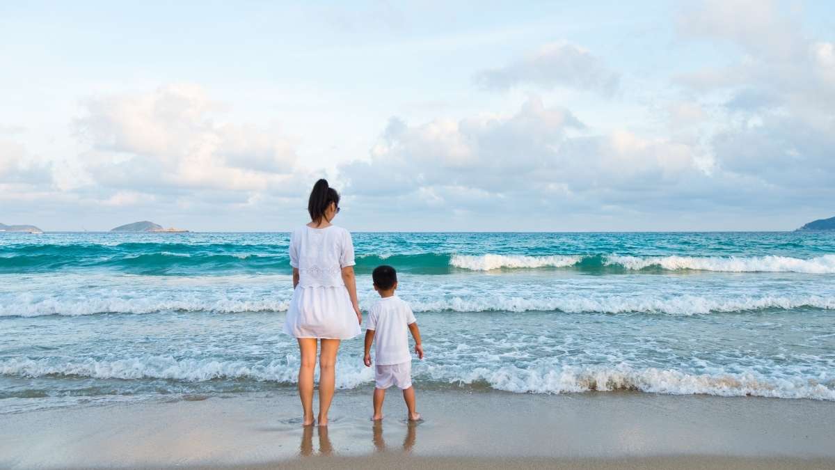 mãe com filho na praia